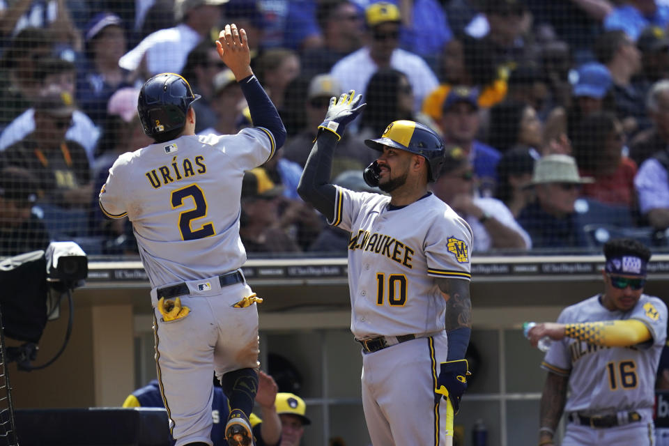 Milwaukee Brewers' Luis Urias (2) is greeted by Omar Narvaez (10) after scoring on a double by Rowdy Tellez during the seventh inning of the team's baseball game against the San Diego Padres, Wednesday, May 25, 2022, in San Diego. (AP Photo/Gregory Bull)