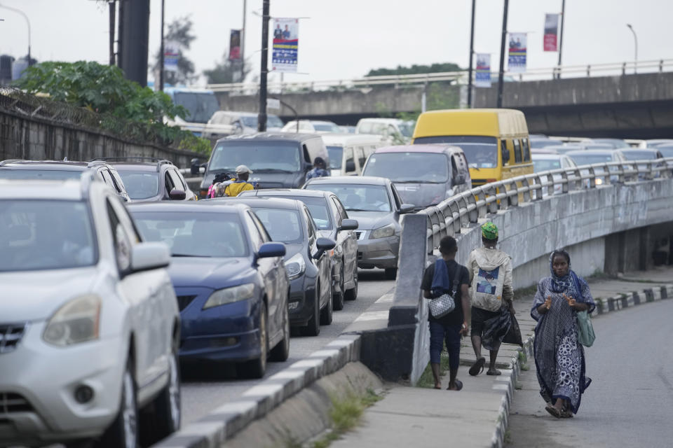 People walk past traffic jams on the bridge of Lagos, Nigeria, Tuesday Sept. 5, 2023. (AP Photo/Sunday Alamba)