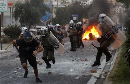 A protester is chased by police during clashes between police and angry anti-fascist protesters following the killing of a 35-year-old anti-racism rapper by a man who sympathized with the far-right Golden Dawn group in an Athens suburb September 18, 2013. REUTERS/Yannis Behrakis