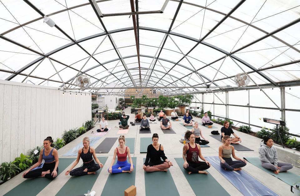 Bija Yoga and Wellness patrons participate in a class in the greenhouse in Orem on Sunday, Jan. 22, 2023. | Jeffrey D. Allred, Deseret News