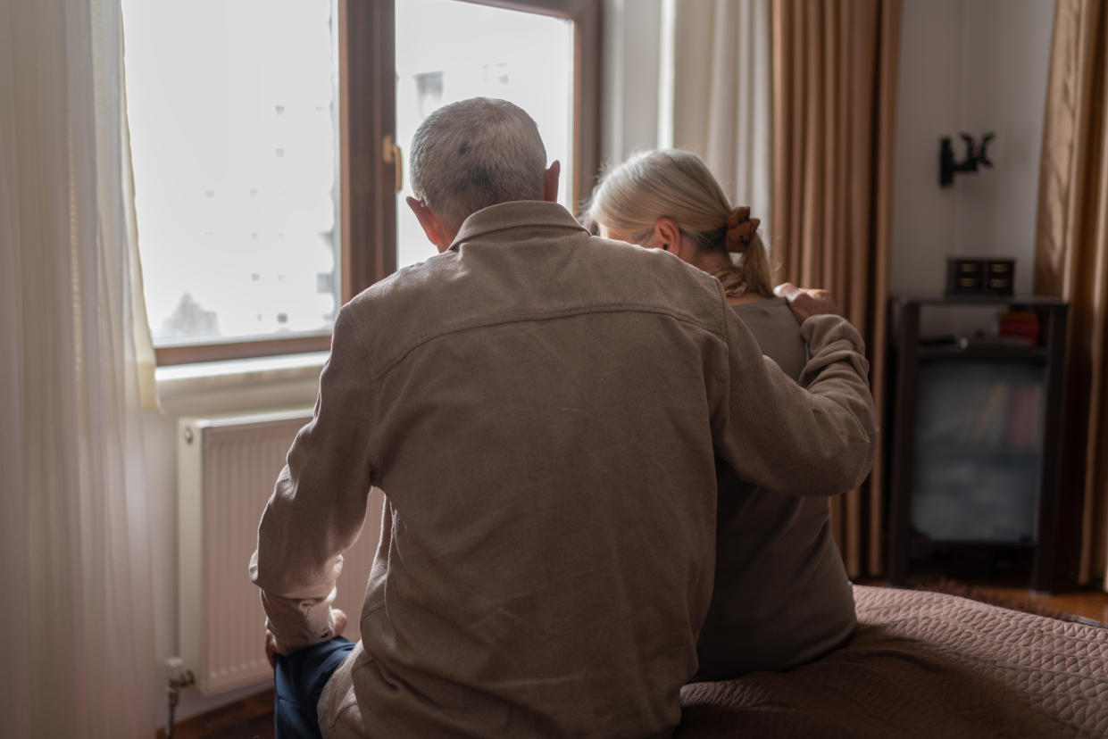 Senior Couple Sitting On The Bed And Looking Away