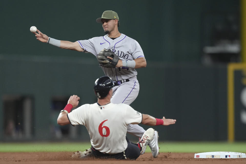 Colorado Rockies shortstop Ezequiel Tovar, top, turns a double play against Texas Rangers' Josh Jung (6) during the second inning of a baseball game in Arlington, Texas, Friday, May 19, 2023. Rangers' Robbie Grossman was out at first. (AP Photo/LM Otero)