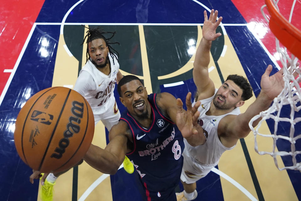 Philadelphia 76ers' De'Anthony Melton, center, goes up for a shot against Cleveland Cavaliers' Darius Garland, left, and Georges Niang during the first half of an NBA basketball in-season tournament game, Tuesday, Nov. 21, 2023, in Philadelphia. (AP Photo/Matt Slocum)