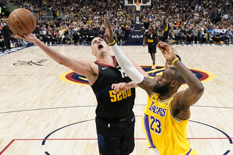 Nikola Jokic (15) of the Denver Nuggets goes up short against Los Angeles Lakers forward LeBron James (23) during the second half of Game 2 of an NBA first-round playoff series, Monday, April 22, 2024, in Denver.  (AP Photo/Jack Dempsey)