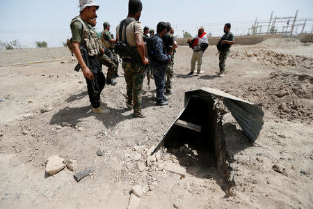 Fighters from the Iraqi Shi'ite Badr Organization stand near a tunnel built by Islamic State fighters on the outskirts of Falluja, Iraq, May 28, 2016. REUTERS/Thaier Al-Sudani