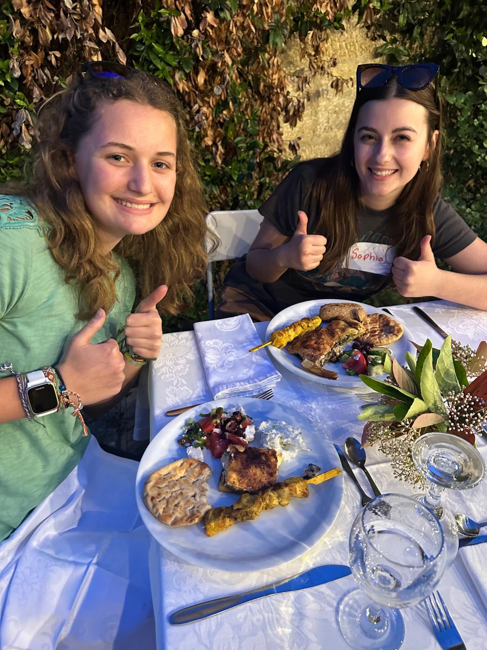 Sophia Preston (R) savoring authentic Greek flavors during the welcome dinner hosted by Dr. Jeff Lansdale, president of the American Farm School, alongside AvaLee Cobbs, a Sandusky 4-H member