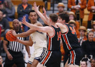 Yale forward EJ Jarvis (15) looks for help against Princeton guard Matt Allocco (14) and forward Zach Martini (54) during the first half of the Ivy League championship NCAA college basketball game, Sunday, March 12, 2023, in Princeton, N.J. (AP Photo/Noah K. Murray)