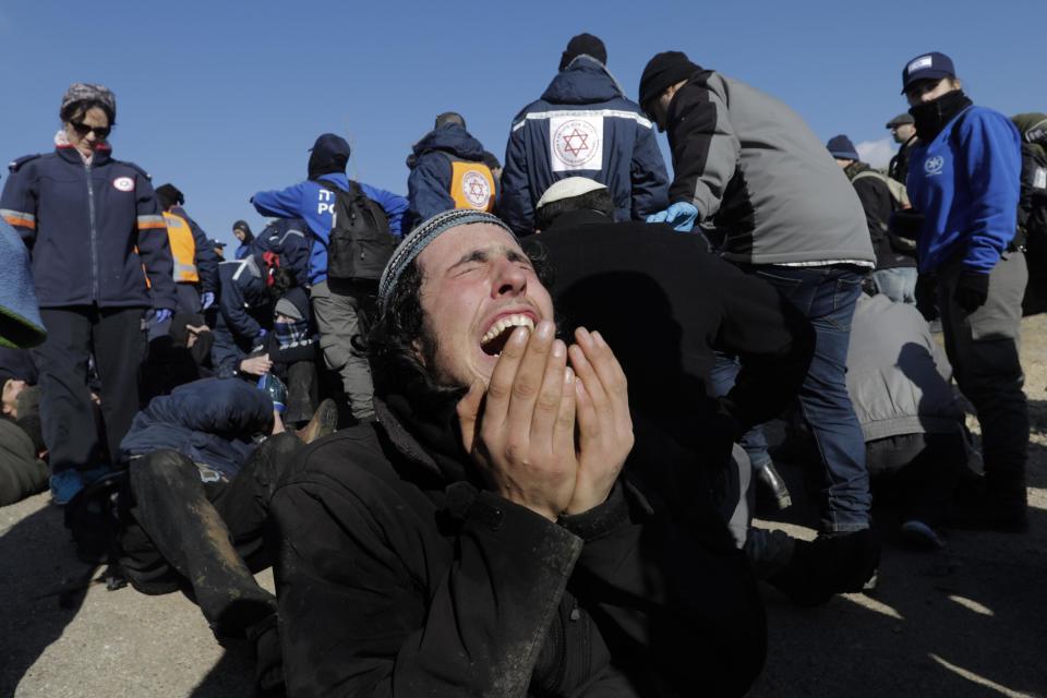 A settler reacts as police evict settlers from the West Bank outpost of Amona Thursday, Feb. 2, 2017. Israeli police removed the remaining Israeli protesters from the West Bank outpost of Amona, which forces are evacuating under court order. The evacuation began Wednesday. Amona is the largest of about 100 unauthorized outposts erected in the West Bank without formal permission but with tacit Israeli government support. The outpost was found to be built on private Palestinian land and the Israeli Supreme Court ordered it demolished. (AP Photo/Tsafrir Abayov)