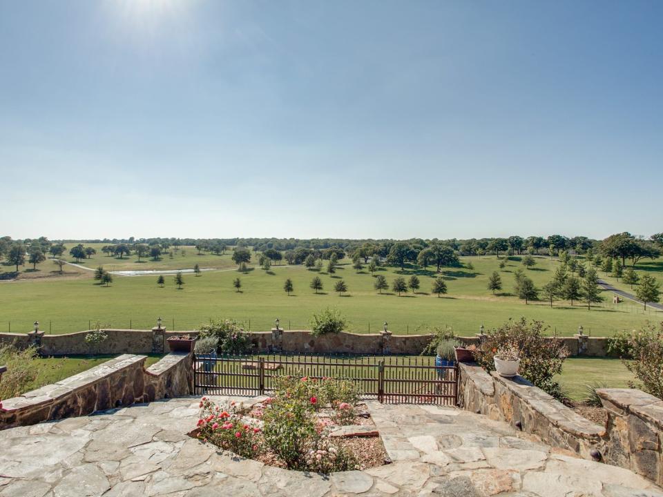 A view from the back patio of Terry Bradshaw's ranch shows sprawling grass land and trees.