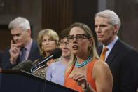 FILE - Sen. Kyrsten Sinema, D-Ariz., center, joined from left by, Sen. Bill Cassidy, R-La., Sen. Lisa Murkowski, R-Alaska, Sen. Susan Collins, R-Maine, and Sen. Rob Portman, R-Ohio, speak to reporters just after a vote to start work on a nearly $1 trillion bipartisan infrastructure package, at the Capitol in Washington, July 28, 2021. Sinema received a $1 million surge of campaign cash over the past year from private equity professionals, hedge funds and venture capitalists whose interests she has staunchly defended in Congress. That's according to an Associated Press review of campaign finance disclosures. (AP Photo/J. Scott Applewhite, File)