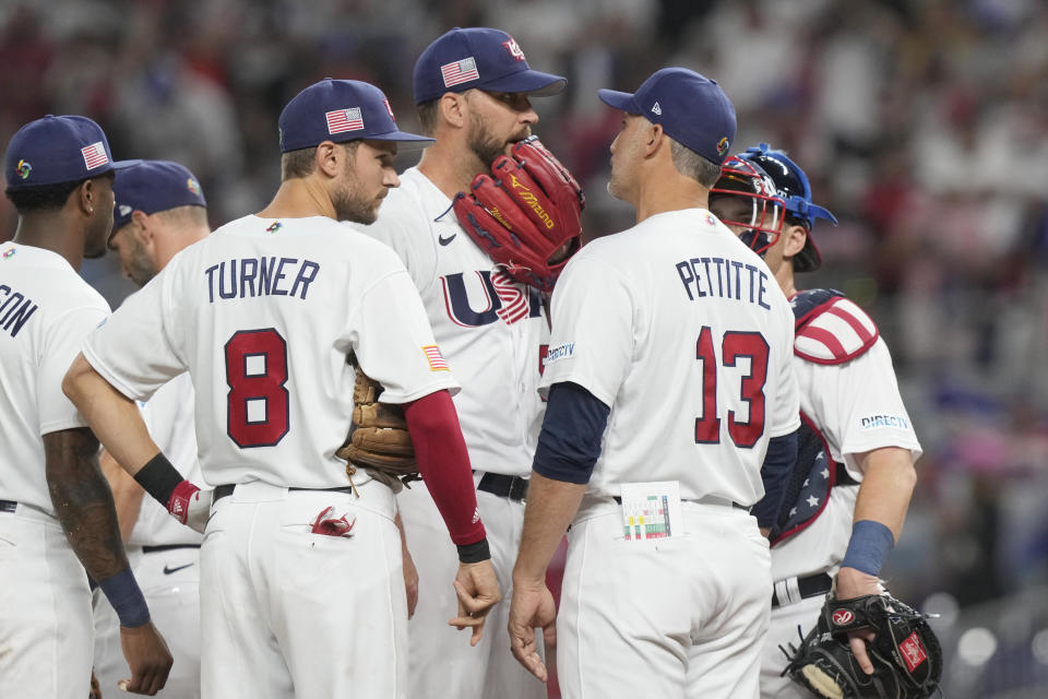 U.S. pitching coach Andy Pettitte (13) talks to starting pitcher Adam Wainwright (50) during the first inning of a World Baseball Classic game against Cuba, Sunday, March 19, 2023, in Miami. (AP Photo/Marta Lavandier)
