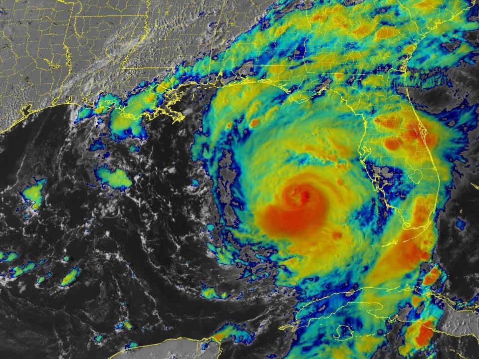 infrared satellite image shows hurricane cyclone north of cuba near florida with a red core and yellow green outer bands