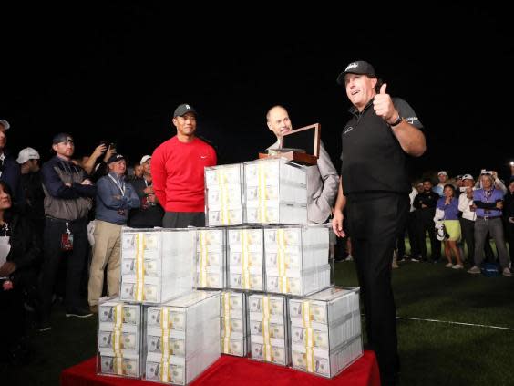 Phil Mickelson poses with $9m after defeating Tiger Woods (Getty)