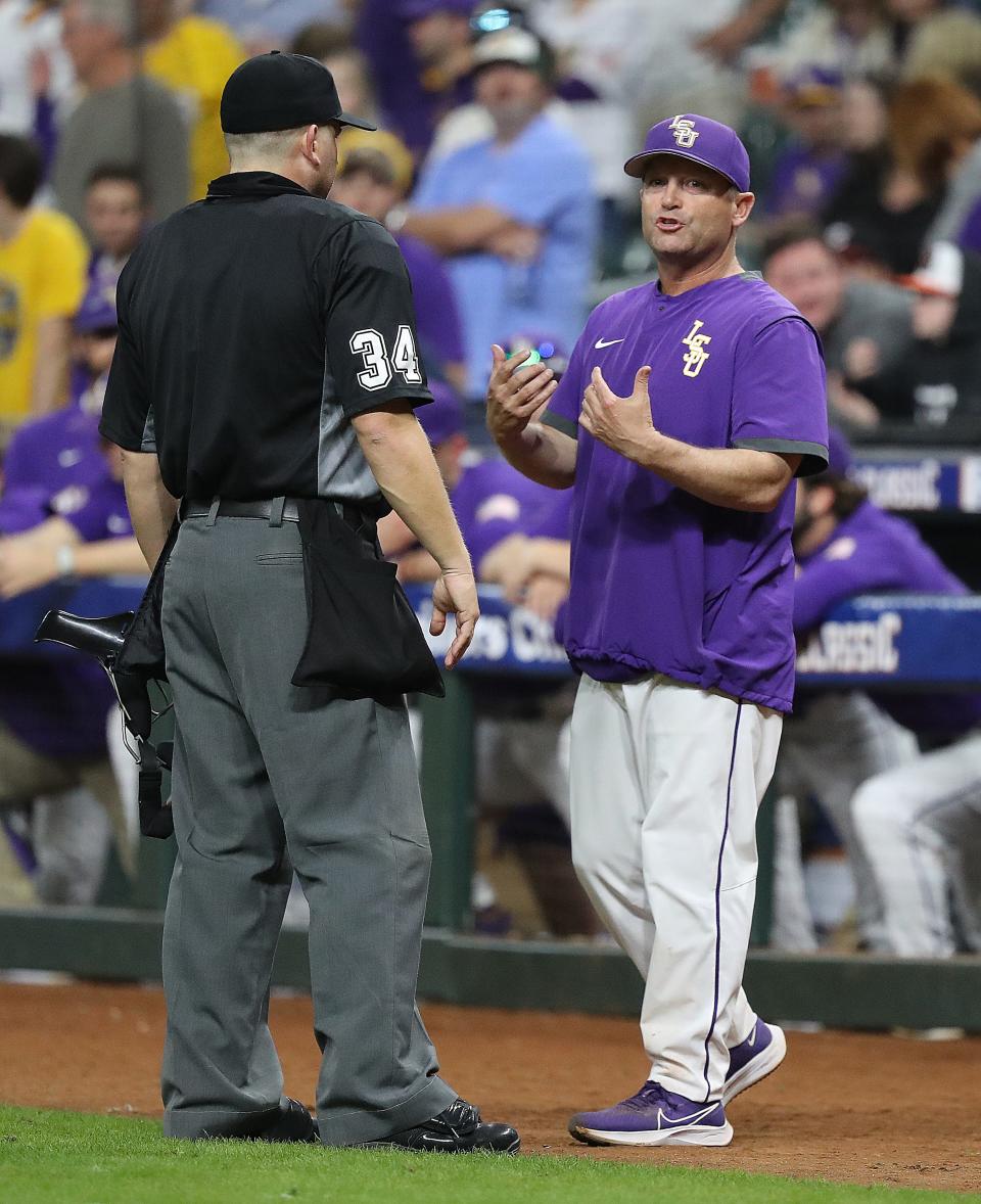 HOUSTON, TEXAS - MARCH 05: Head coach Jay Johnson of the LSU Tigers argues with the home plate umpire after the runner was sent back to first base when it was determined that the ball hit the wall before Douglas Hodo #7 of the Texas Longhorns attempted to catch the ball and Dylan Campbell #8 backing him up caught the ball before hitting the ground\ during the Shriners Children's College Classic at Minute Maid Park on March 05, 2022 in Houston, Texas. (Photo by Bob Levey/Getty Images)