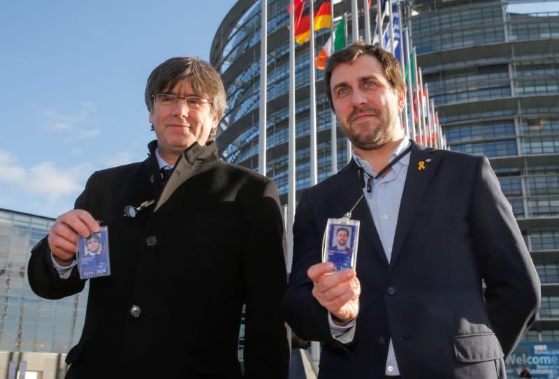 Los exmiembros del Gobierno catalán Carles Puigdemont y Toni Comín muestran sus insignias a su llegada para asistir a su primera sesión plenaria como miembros del Parlamento Europeo en Estrasburgo, Francia, el 13 de enero de 2020