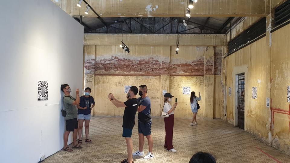 Visitors at the Hin Bus Depot gallery viewing the AR sculptures using the Perk Reality app on their smartphones. — Picture courtesy of Aboud Fares