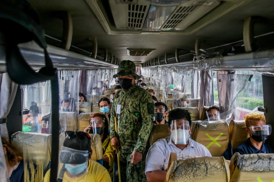 A member of the Philippine National Police checks a bus to make sure the passengers follow COVID-19 health protocols at a police checkpoint in Quezon City, the Philippines on Aug. 6, 2021.  The Philippines' Department of Health DOH reported on Friday 10,623 new coronavirus disease (COVID-19) infections, bringing the total number of confirmed cases in the Southeast Asian country to 1,638,345. (Photo by Rouelle Umali/Xinhua via Getty Images)