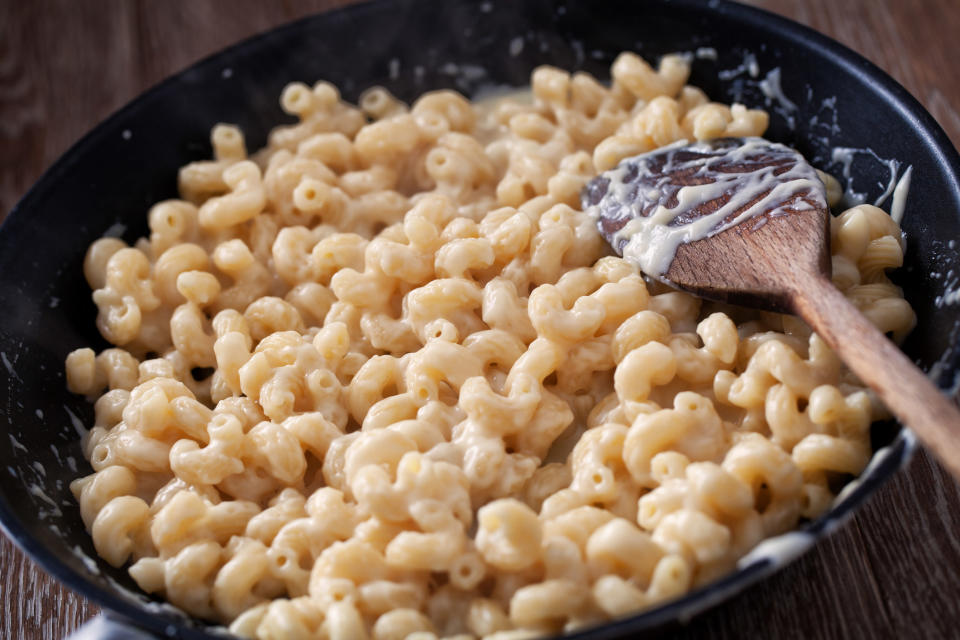 Cooking macaroni and cheese in a skillet.
