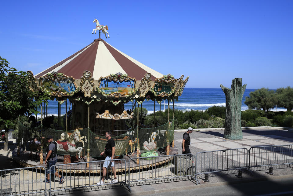 French special forces walk past a carousel after participating in a de-mining operation along the beach inside the red zone with the venue in the background as security is stepped-up ahead of the G-7 summit in Biarritz, France Friday, Aug. 23, 2019. U.S. President Donald Trump will join host French President Emmanuel Macron and the leaders of Britain, Germany, Japan, Canada and Italy for the annual G-7 summit in the elegant resort town of Biarritz. (AP Photo/Peter Dejong)