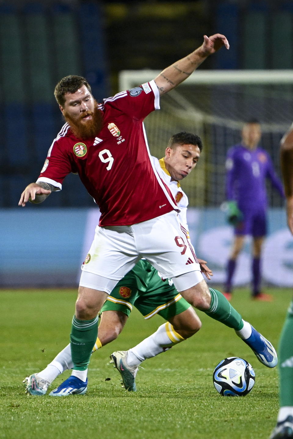 Hungary's Martin Adam, front, and Bulgaria's Filip Krastev, rear, challenge for the ball during the Euro 2024 group G qualifying soccer match between Bulgaria and Hungary at the Vasil Levski National Stadium in Sofia, Bulgaria, Thursday, Nov. 16, 2023. (Zsolt Szigetvary/MTI via AP)