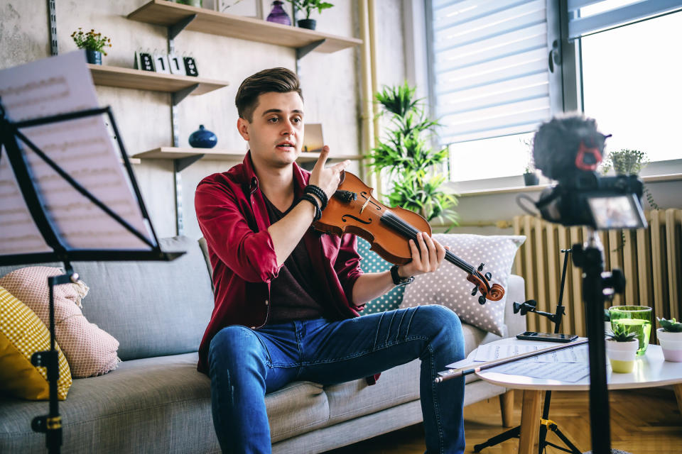 Man recording an online violin lesson at home