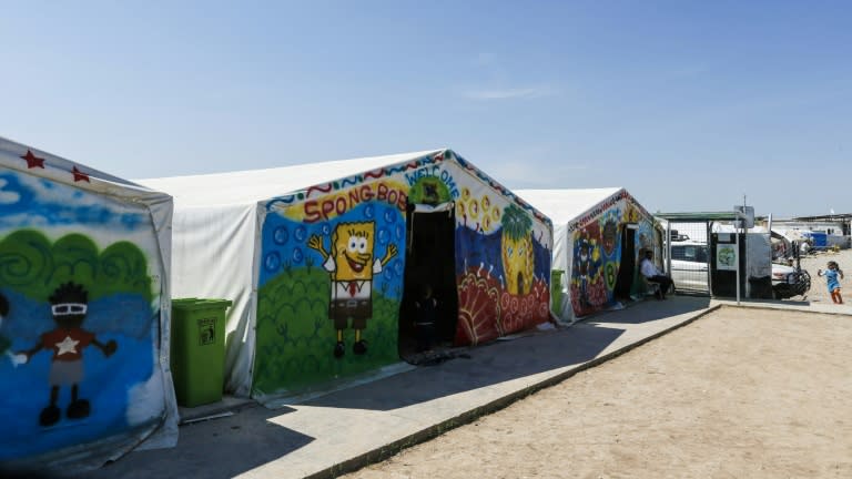 Facilities at Hasan Sham camp for the displaced, east of Mosul, are basic, the tents daubed with bright murals, technicolour handprints and SpongeBob SquarePants 