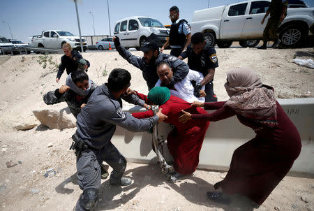 FILE PHOTO: Israeli policemen try to detain Palestinians in the Bedouin village of al-Khan al-Ahmar near Jericho in the occupied West Bank July 4, 2018. REUTERS/Mohamad Torokman/File Photo 