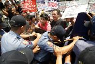 Anti-riot policemen use their shields to push back protesters making their way to the U.S. embassy during a protest against the upcoming visit of U.S. President Barack Obama next week, in Manila April 23, 2014.