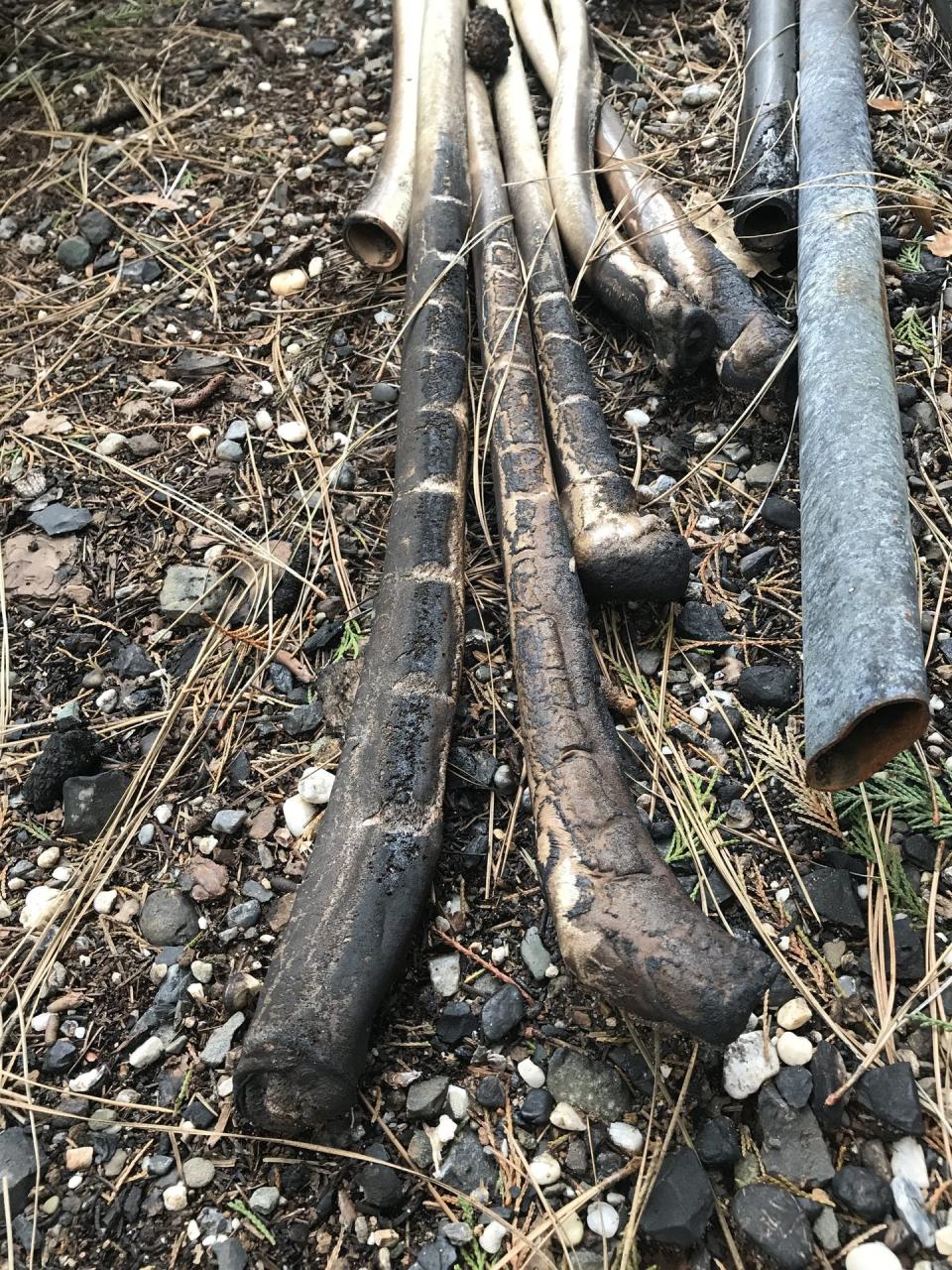 Melted plastic pipes alongside metal pipes.