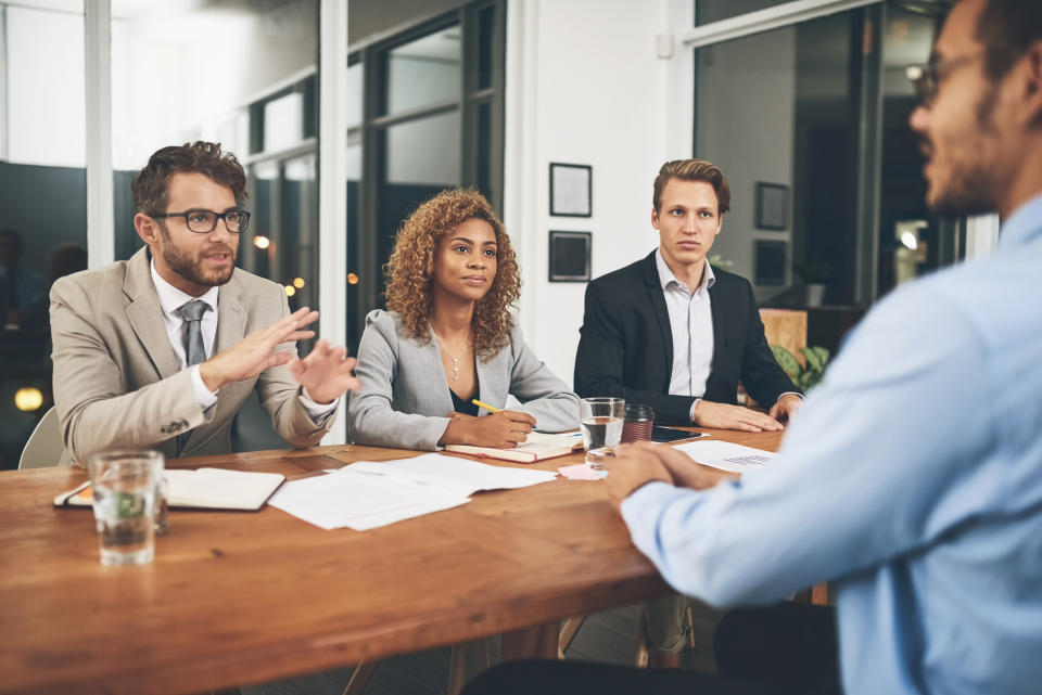 A group of businesspeople interviewing a candidate in an office.