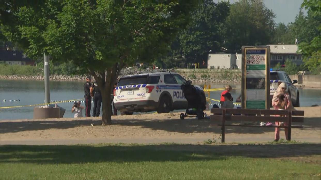 Ottawa police at Britannia Beach west of downtown Ottawa Monday afternoon. A child who had been pulled from the water has died, police said Tuesday. (Brian Morris/CBC - image credit)