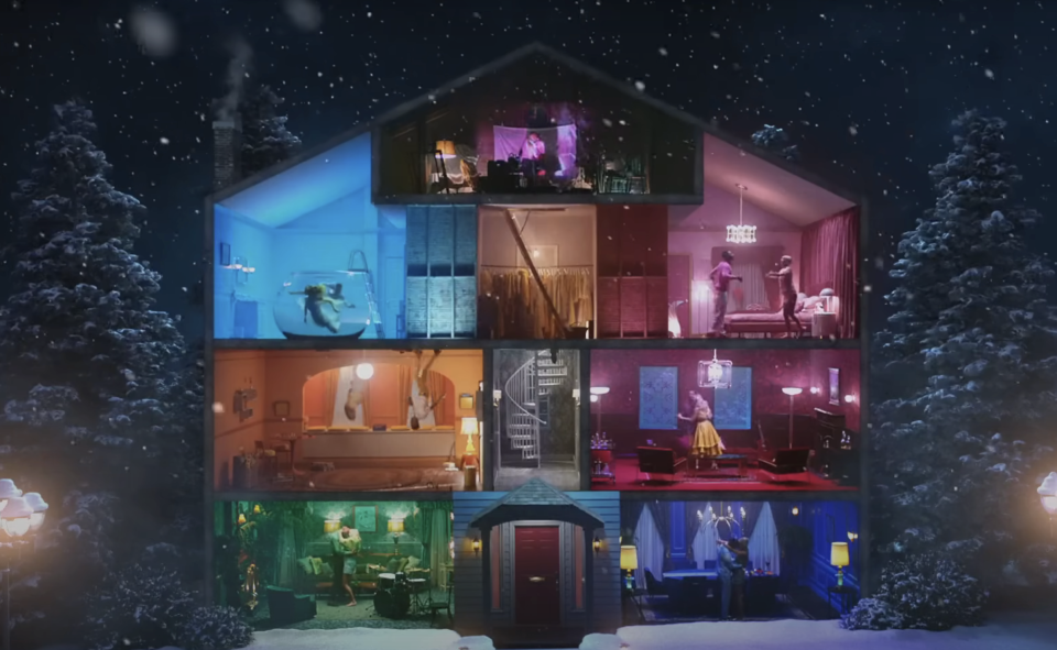 Cross-section of a multi-story house with characters in various rooms engaged in different activities, set in a snowy night scene