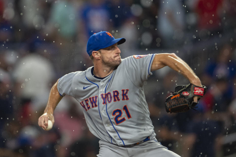 New York Mets starting pitcher Max Scherzer (21) throws in the rain during the third inning of the team's baseball game against the Atlanta Braves on Wednesday, Aug. 17, 2022, in Atlanta. (AP Photo/Hakim Wright Sr.)