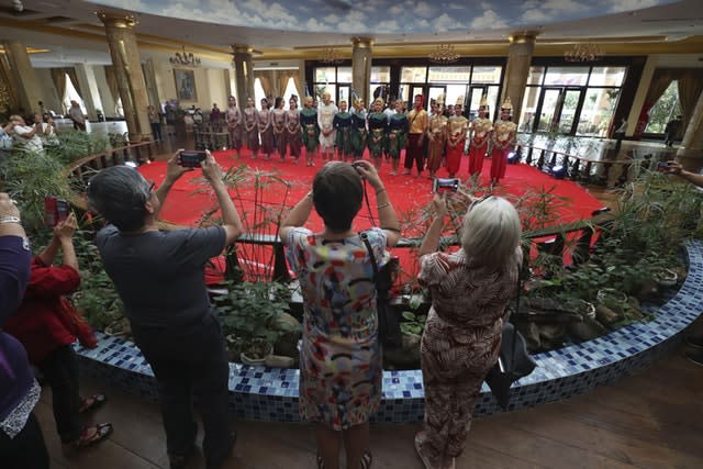 Passengers from the cruise ship Westerdam take a photo of Cambodian dancers after their performance at a hotel in Phnom Penh, Cambodia