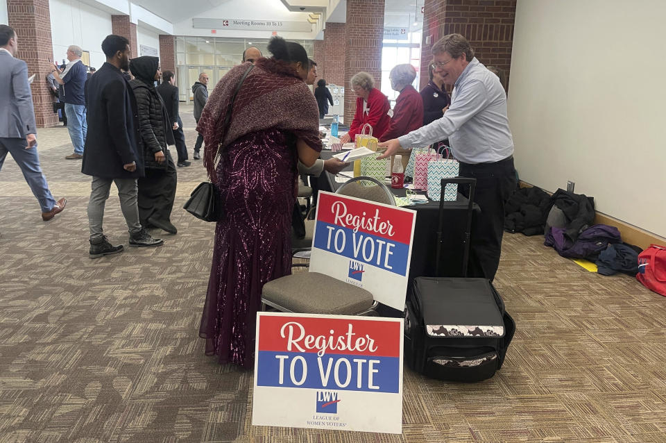 Varias personas se registran para poder votar tras convertirse en ciudadanos estadounidenses durante una ceremonia de obtención de la nacionalidad en un centro de convenciones de St. Paul, Minnesota, el 9 de marzo de 2023. Se está actualizando el examen de ciudadanía estadounidense y algunos inmigrantes y defensores de los derechos humanos temen que los cambios perjudiquen a los aspirantes con menor nivel de inglés. El examen es uno de los pasos finales hacia la obtención de la ciudadanía... un proceso de meses de duración que requiere una residencia legal permanente durante años antes de solicitarla. (AP Foto/Trisha Ahmed)