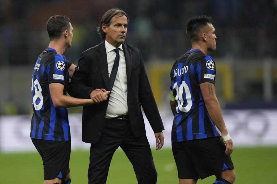Inter Milan's head coach Simone Inzaghi, center, congratulates his players Benjamin Pavard, left, and Lautaro Martinez at the end of the Champions League, Group D soccer match between Inter Milan and Benfica, at the San Siro stadium in Milan, Italy, Tuesday, Oct. 3, 2023. Inter Milan won 1-0. (AP Photo/Luca Bruno)