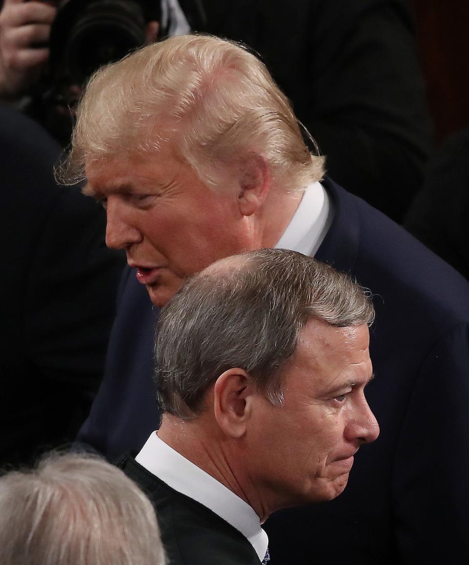 President Donald Trump passes by an unsmiling Chief Justice John Roberts before delivering his State of the Union address in the chamber of the U.S. House of Representatives earlier this year.
