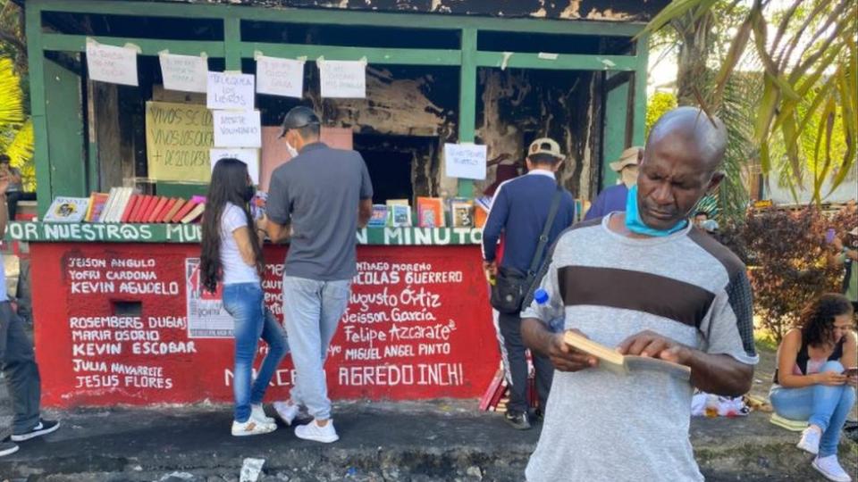 Un hombre mira un libro en Cali.