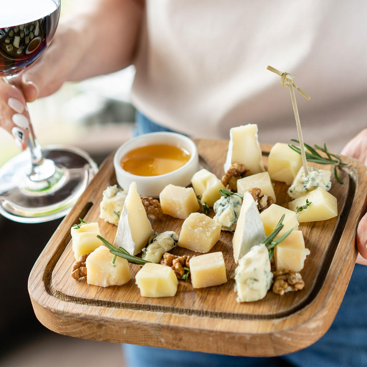 woman holding tray of cheeses