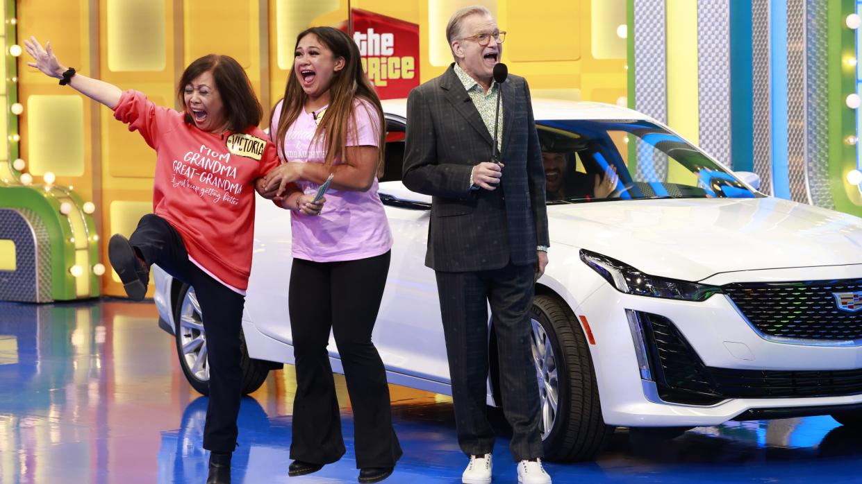  Drew Carey celebrating with contestants on The Price Is Right at Night. 