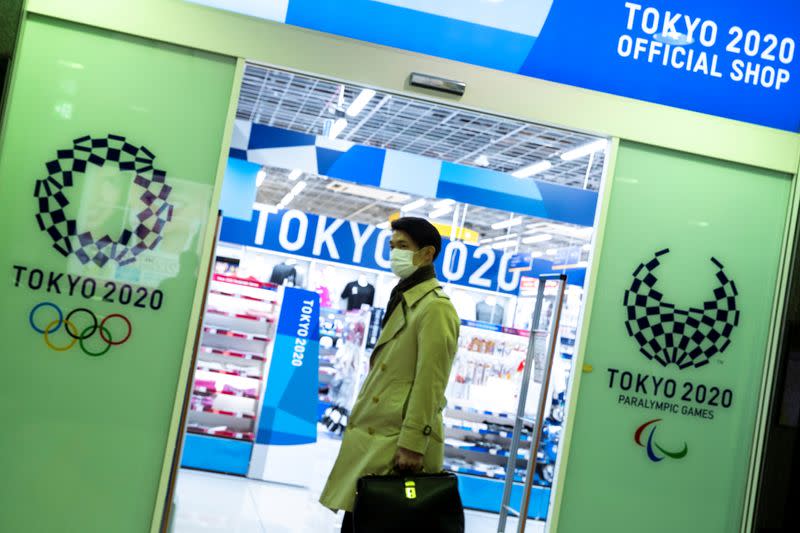 A man wearing a protective face mask, following an outbreak of the coronavirus disease (COVID-19), walks past a Tokyo Olympics 2020 sourvenir shop in Tokyo