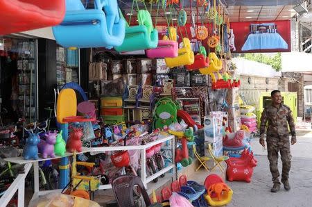 An Iraqi security force member walks past a toy store in east Mosul, Iraq April 30, 2017. REUTERS/Marius Bosch