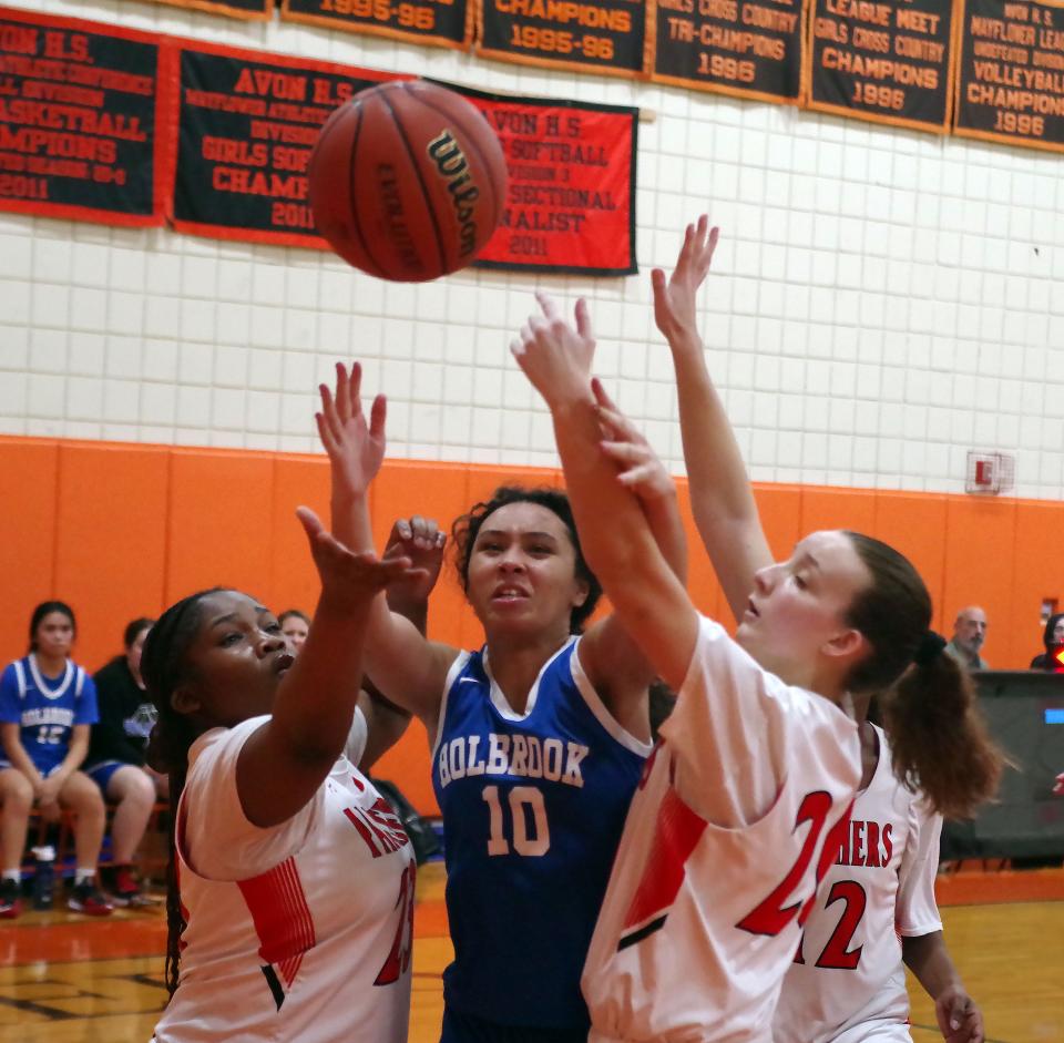 Madison Burnett of Holbrook gets off a shot while in between Avon's Uwa Idada (left) and Kylie Andersen on Thursday, Feb. 16, 2023.