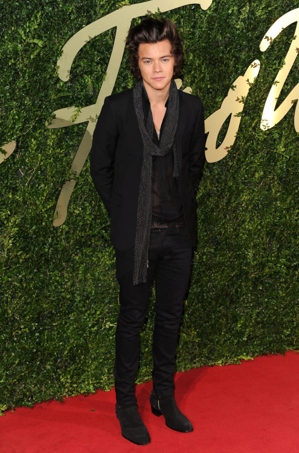 <p>In a semi-sheer shirt, loose scarf and his signature skinny trousers, Styles cut a fashionable figure at his first British Fashion Awards back in 2013. <i>[Photo: Rex]</i></p>