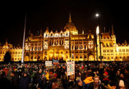 People stand in front of the parliament building during a protest against a proposed new labor law, billed as the "slave law", in Budapest, Hungary, December 16, 2018. REUTERS/Leonhard Foeger