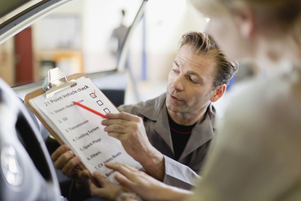 mechanic showing checklist to interested buyer