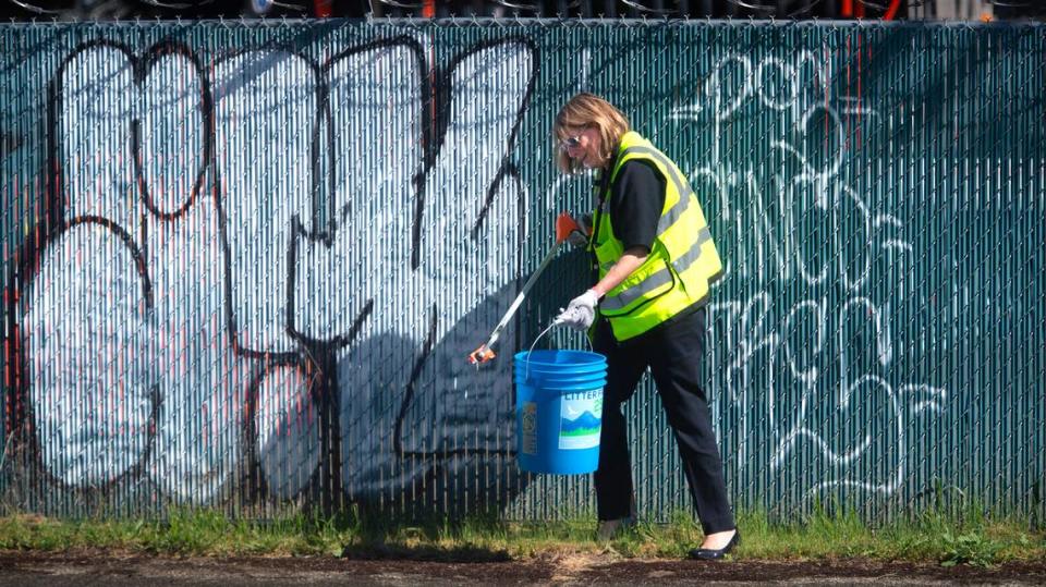 Tacoma city council member Sarah Rumbaugh picks up trash during a joint project between Litter Free 253 and Tidy-Up Tacoma to clean up and document trash along South 88th Street and Pacific Avenue on Tuesday, May 14, 2024.