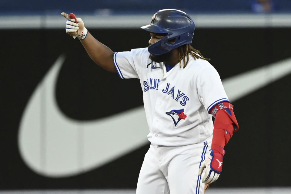 Toronto Blue Jays' Vladimir Guerrero Jr. gestures to the dugout after hitting a double against the Cleveland Guardians during the fourth inning of a baseball game Friday, Aug. 12, 2022, in Toronto. (Jon Blacker/The Canadian Press via AP)