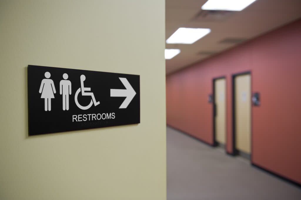 A sign along a hallway points to restrooms.