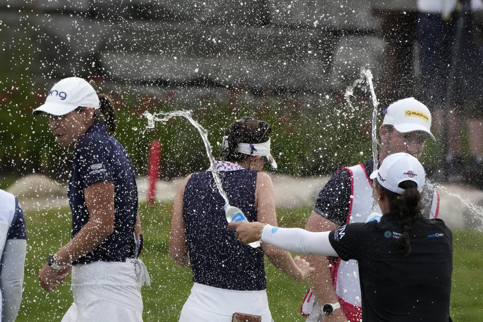 Emma Talley, right, sprays Elizabeth Szokol, left, and Cheyenne Knight after they won the Dow Great Lakes Bay Invitational golf tournament at Midland Country Club, Saturday, July 22, 2023, in Midland, Mich. (AP Photo/Carlos Osorio)